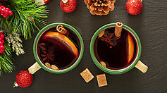 Mulled wine, Christmas hot drink in mugs on black stone, closeup view